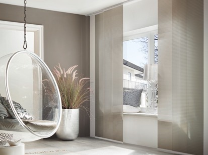 Graues Zimmer mit rundem Transparenten Sessel mit Fenster und grauen Flaechenvorhang