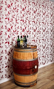 Fass mit Wein vor Wand mit Pflanzen Tapete rot