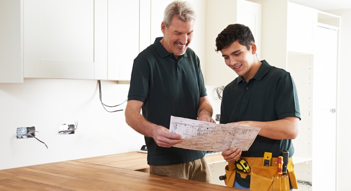Junger, Aelterer Handwerker bauen Küche ein